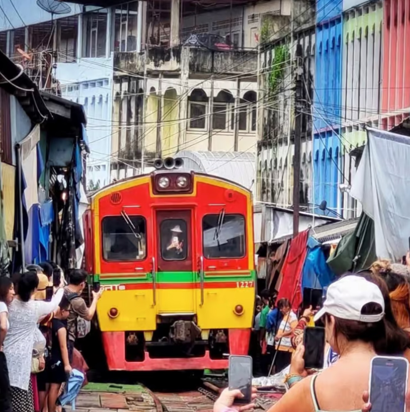 Maeklong Railway Market med tog gjennom markedet